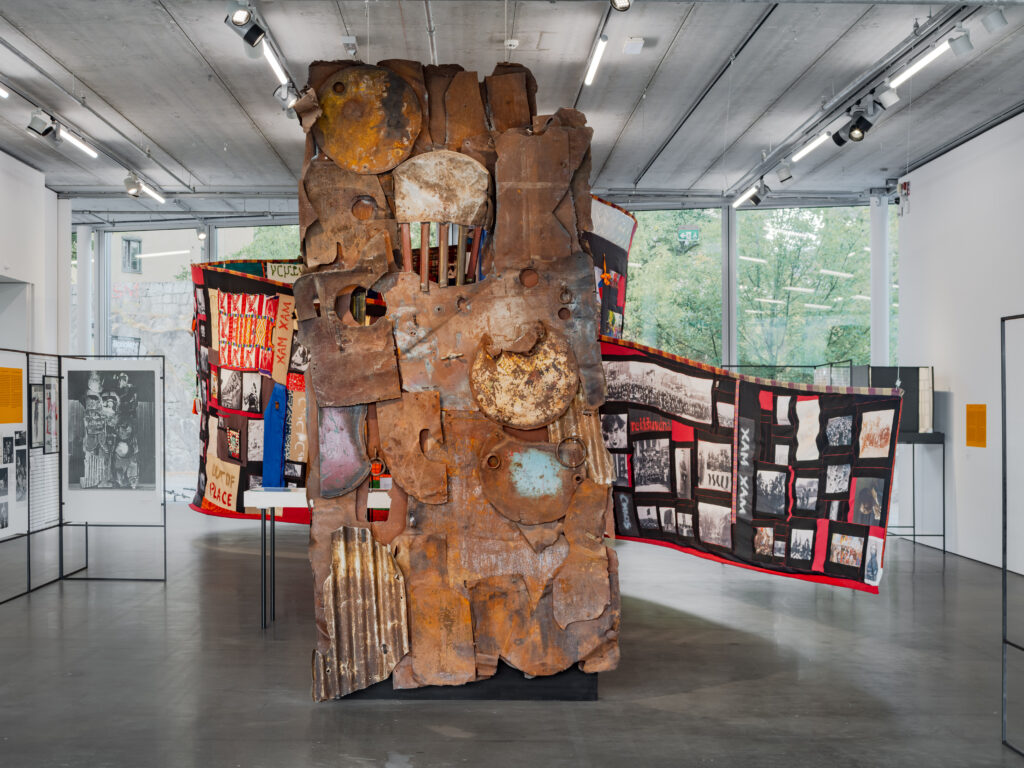Förgrund: Gunilla Palmstierna-Weiss, Skråpuken, 1967. Bakgrund: Hamedine Kane & Valérie Osouf, Where the Seams Hold Against the Fixed Narrative, 2026. Foto: Bonniers Konsthall (Jean-Baptiste Béranger)
